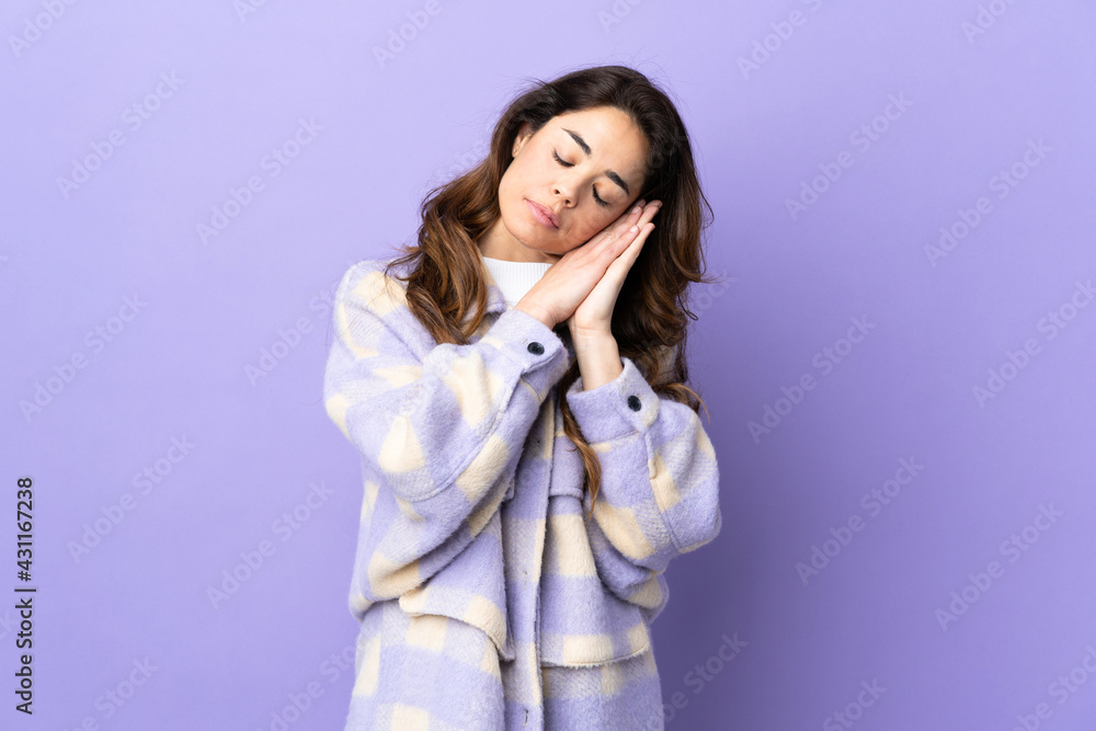 Woman over isolated purple background making sleep gesture in dorable expression Woman over isolated purple background making sleep gesture in dorable expression