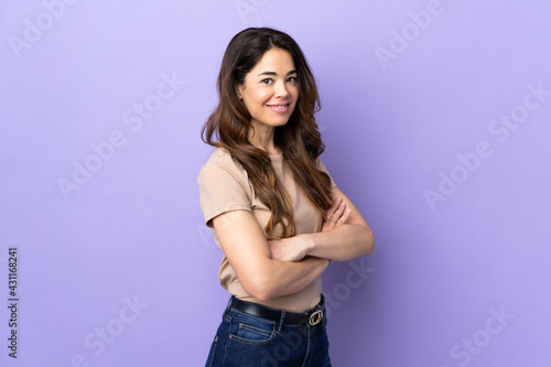 Woman over isolated purple background looking to the side and smiling