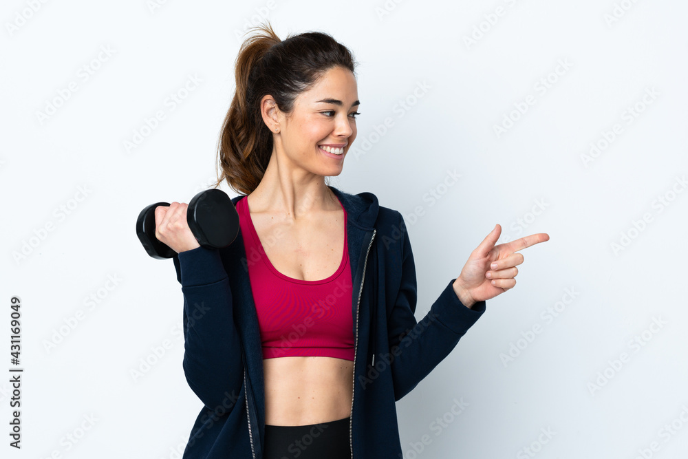 Sport woman making weightlifting over isolated white background pointing to the side to present a product Sport woman making weightlifting over isolated white background pointing to the side to present a product