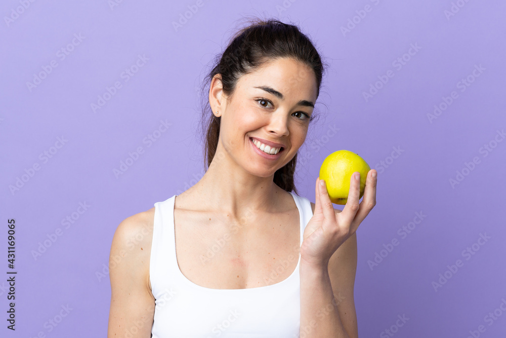 Woman over isolated purple background with an apple Woman over isolated purple background with an apple