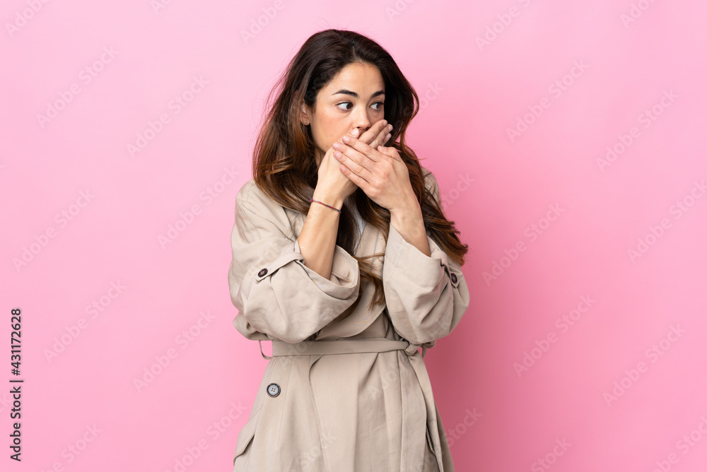 Woman over isolated background covering mouth and looking to the side Woman over isolated background covering mouth and looking to the side