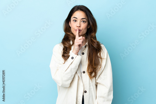 Woman over isolated background showing a sign of silence gesture putting finger in mouth