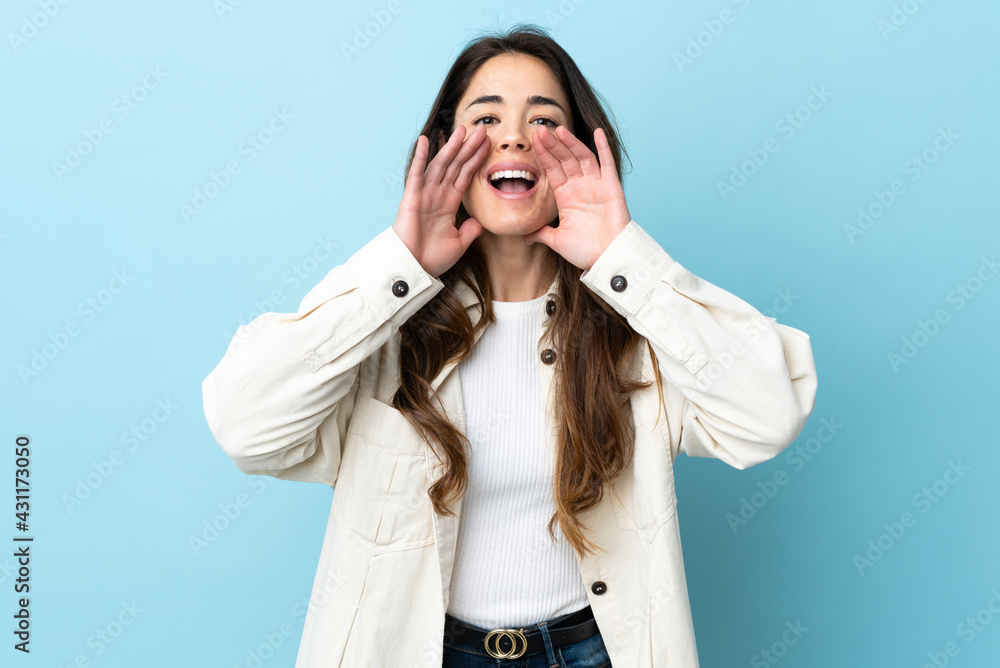 Woman over isolated background shouting and announcing something Woman over isolated background shouting and announcing something