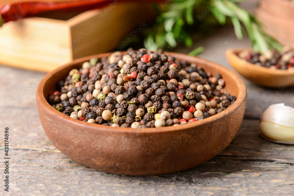 Bowl with peppercorns on wooden background Bowl with peppercorns on wooden background