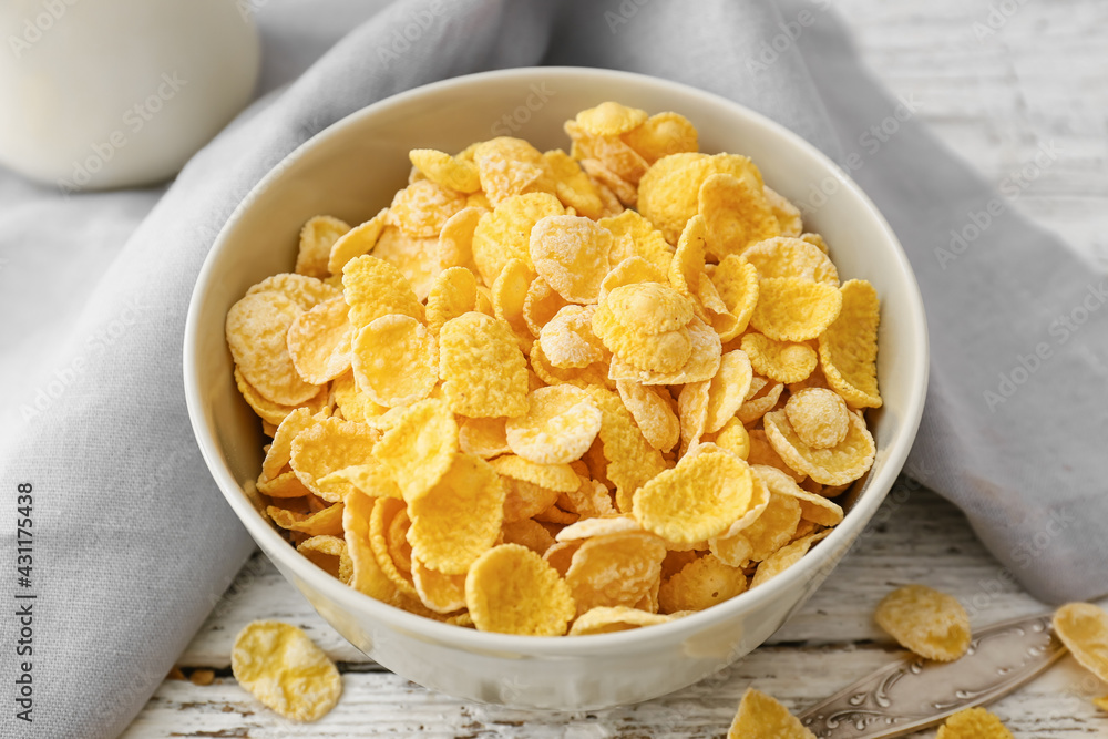 Bowl with tasty cornflakes on light wooden background Bowl with tasty cornflakes on light wooden background