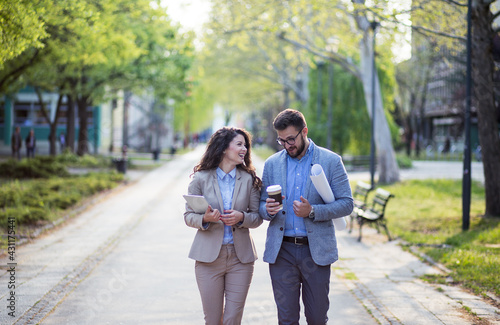 Two business people taking a walk in park
