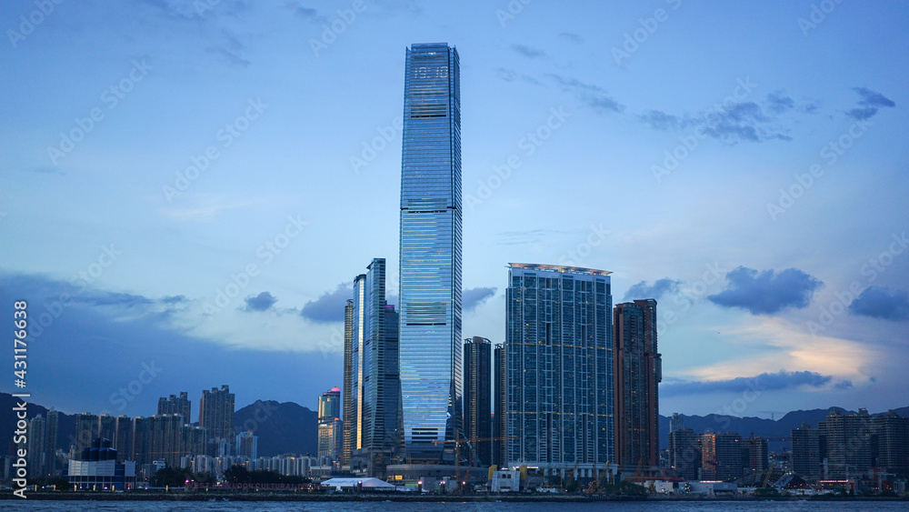 Hong Kong - June 25, 2016: city skyline view in Hong Kong at sunset, IFC building, blue sky, modern architecture, illustrative editorial