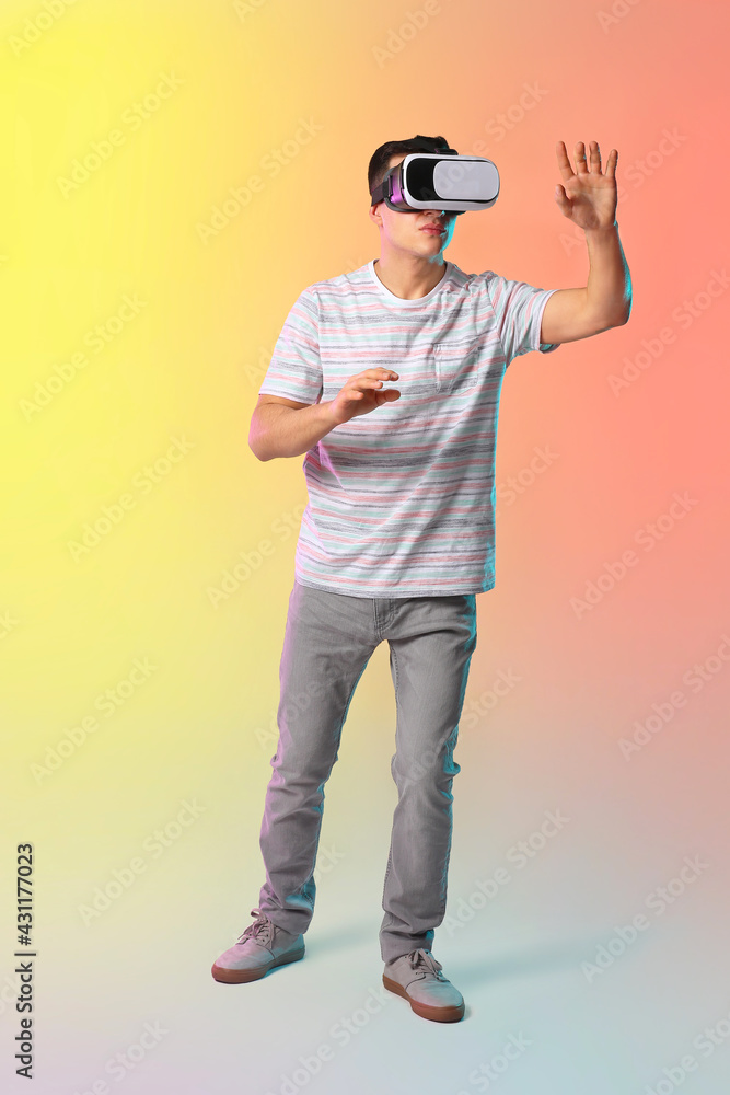 Young man with virtual reality glasses on color background Young man with virtual reality glasses on color background