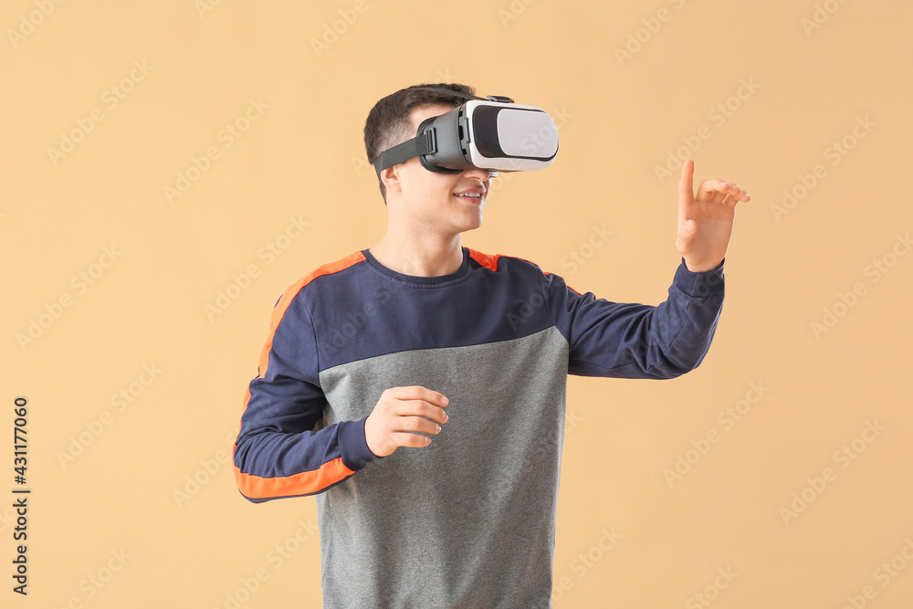 Young man with virtual reality glasses on color background Young man with virtual reality glasses on color background