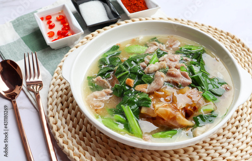 Stir fried noodles with pork and kale in gravy sauce (Thai food called Rad Na Moo) - close up view with seasoning