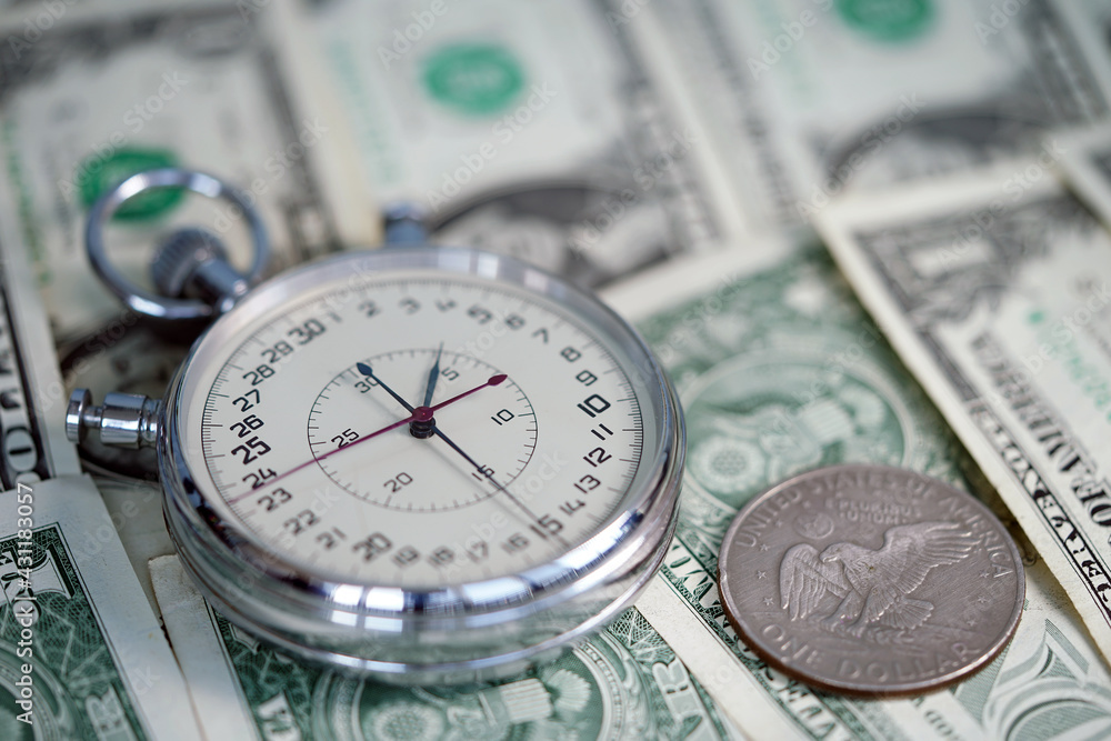 Time is money. Dollar close up. Money macro shot. The stopwatch lies on the dollars. Chronograph. Measurement. Rapidity Force Speed. Time is money. Dollar close up. Money macro shot. The stopwatch lies on the dollars. Chronograph. Measurement. Rapidity Force Speed.