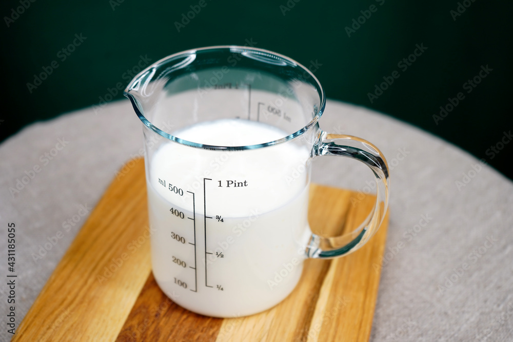 Kefir in a glass dish. Dairy product in a measuring glass top view. Proteins. Fermented milk yogurt. Calcium. Diet drink Kefir in a glass dish. Dairy product in a measuring glass top view. Proteins. Fermented milk yogurt. Calcium. Diet drink