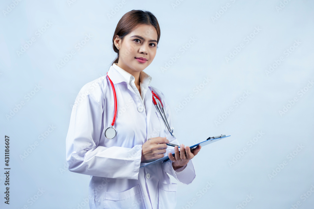 Smiling beautiful asian female doctor with lab coat holding a clipboard isolated on gray background, she is looking at camera Smiling beautiful asian female doctor with lab coat holding a clipboard isolated on gray background, she is looking at camera