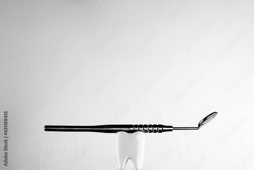 White healthy tooth, holding a mirror dental tool for DENTAL CARE. White healthy tooth, holding a mirror dental tool for DENTAL CARE.