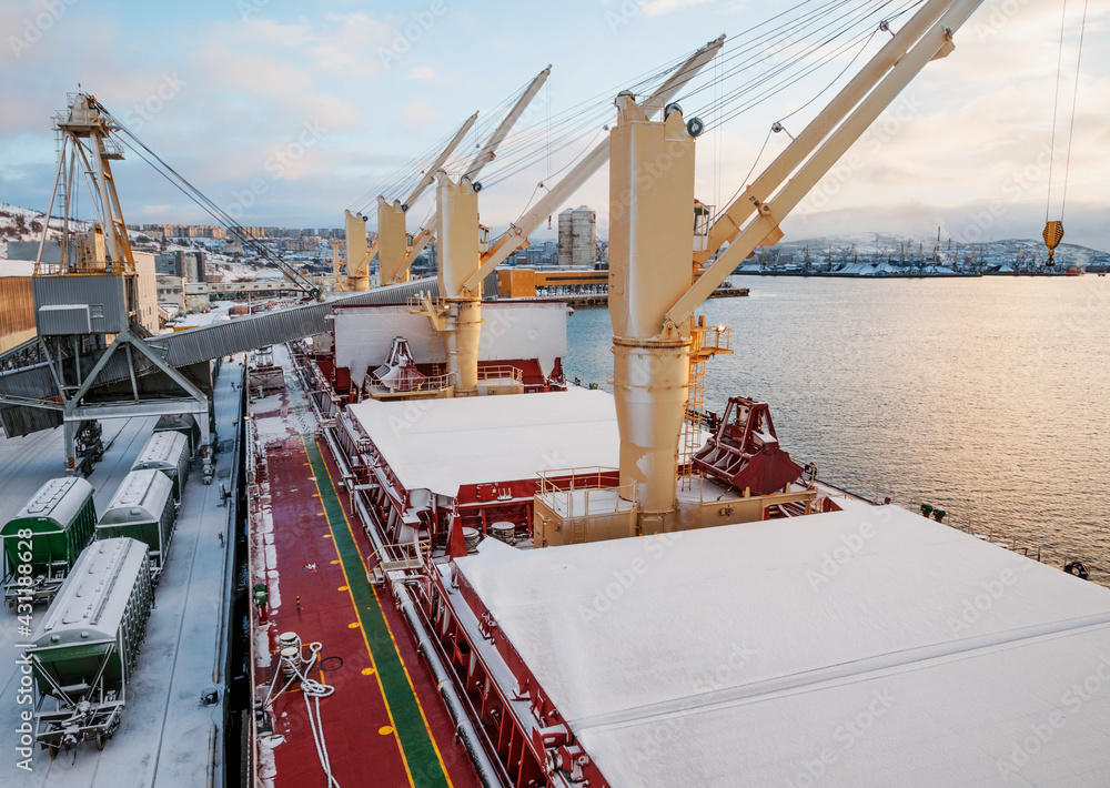 Dry cargo deck covered with a thin layer of snow
Bulk carrier at the mooring wall in the seaport, awaiting loading operations