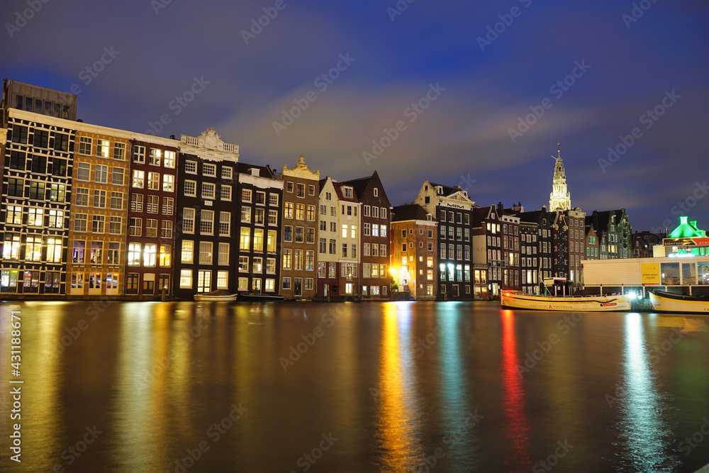 Amsterdam dancing houses on Damrak illuminated lit up at night houses with dutch architecture by the canal Amsterdam Netherlands