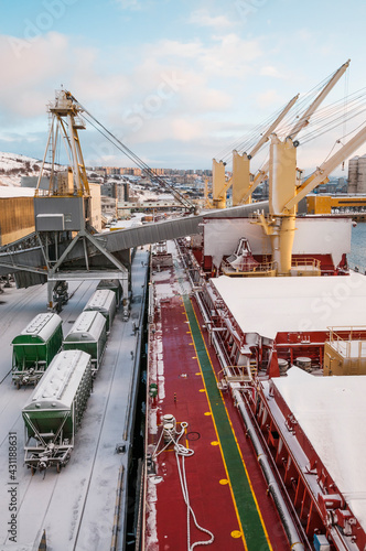 Dry cargo deck covered with a thin layer of snow
Bulk carrier at the mooring wall in the seaport, awaiting loading operations