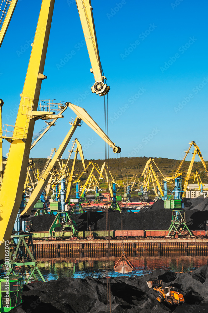 Mountains of coal in the seaport and many gantry cranes with buckets. Mountains of coal in the seaport and many gantry cranes with buckets.