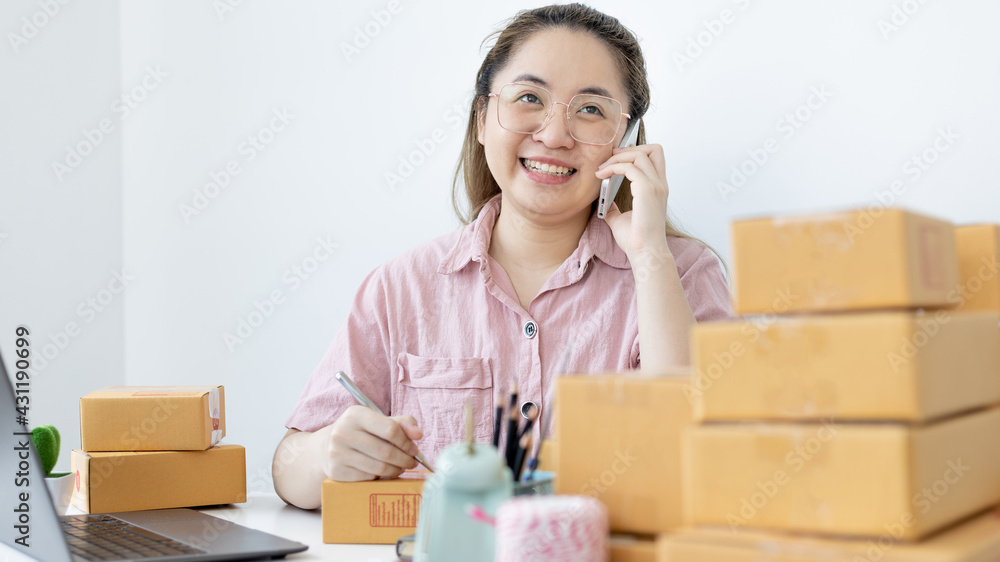 Young woman selling products online was talking on the phone to receive an order from a customer who called and wrote down the list in a notebook, New kind of business for young, Sell online. Young woman selling products online was talking on the phone to receive an order from a customer who called and wrote down the list in a notebook, New kind of business for young, Sell online.