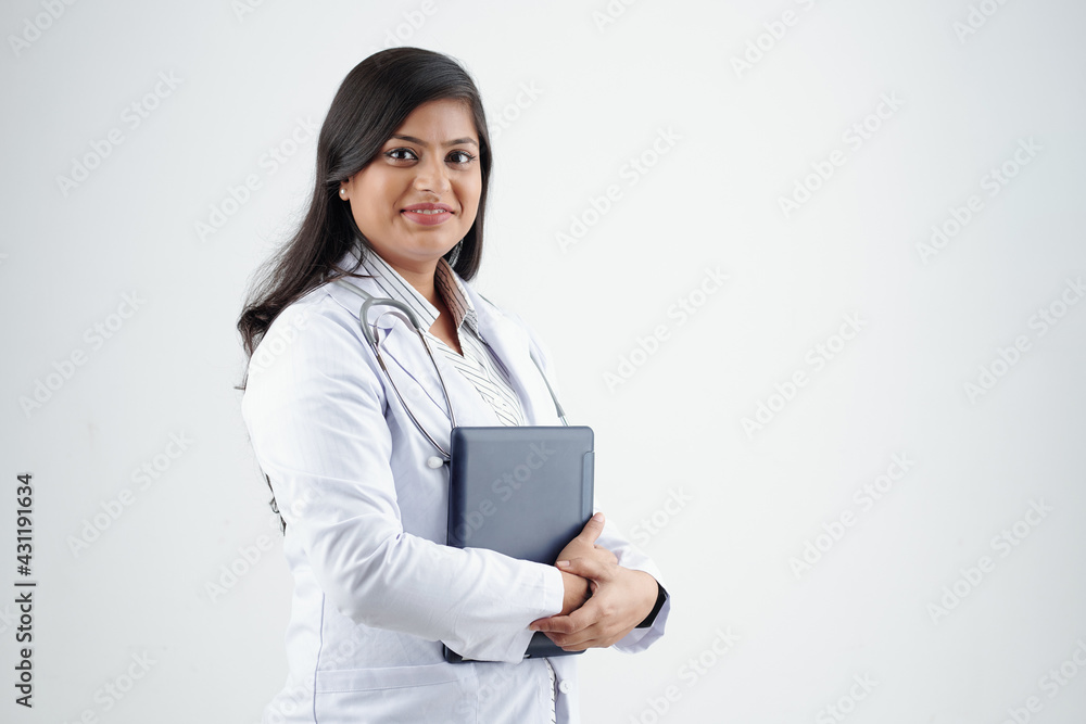 Pretty confident young Indian doctor posing with tablet computer against white background