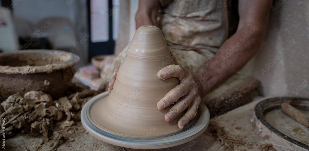 Potter hand working carefully on pottery, closeup view Potter hand working carefully on pottery, closeup view