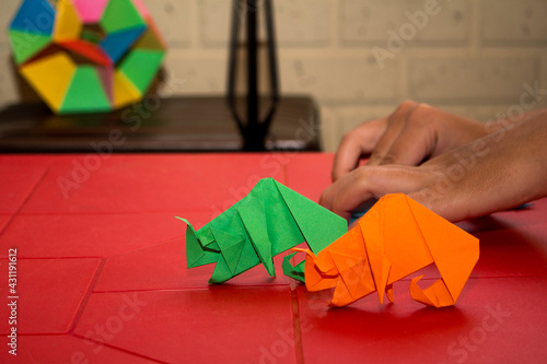 colorful chameleons in origami on a red table
