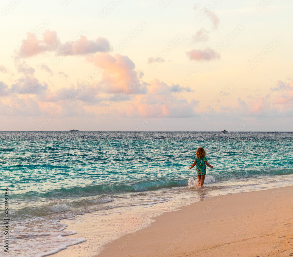Little girl walking on the beach. Outdoors