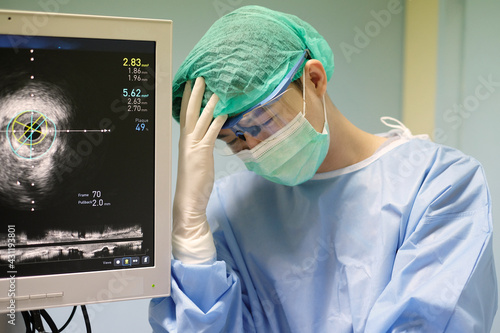 doctor used Intravascular ultrasound imaging (IVUS) machine and with emotional stress of overworked at cardiac catheterization laboratory room