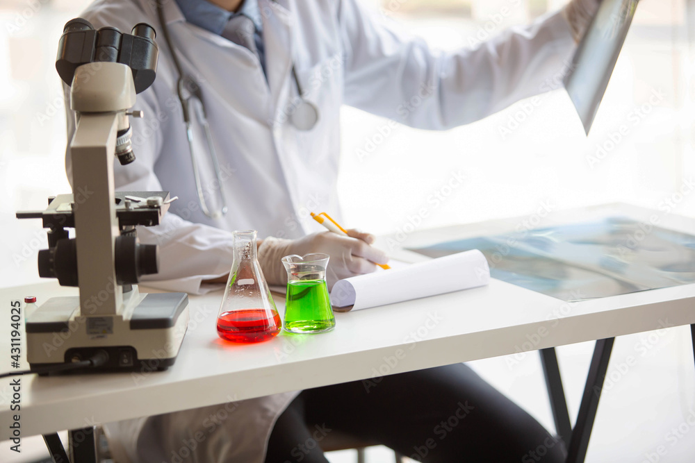 The doctor is testing a sample of biological tubes contaminated by Corona-virus Covid 19 and searching for a vaccine or Syrup against the virus. In the laboratory and film samples of infected lung The doctor is testing a sample of biological tubes contaminated by Corona-virus Covid 19 and searching for a vaccine or Syrup against the virus. In the laboratory and film samples of infected lung