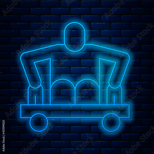 Glowing neon line Man without legs sitting wheelchair icon isolated on brick wall background. Disability concept. Guy with physical disabilities. Vector