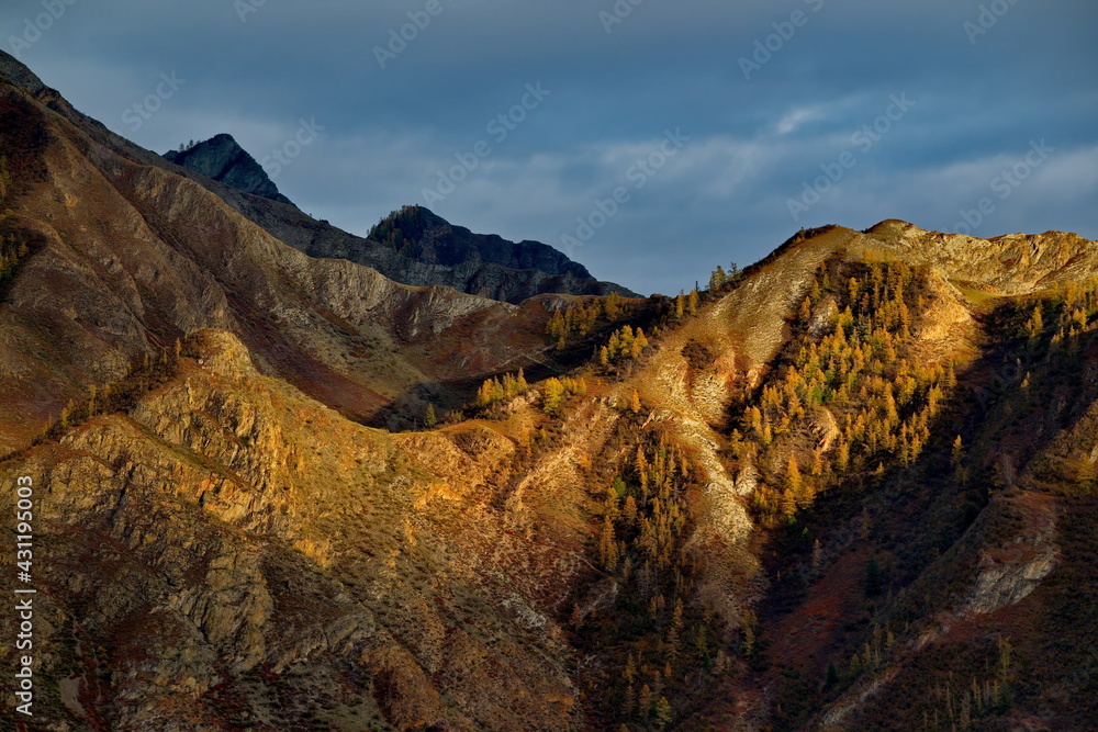 Russia. Mountain Altai. Expressive graphics of autumn sunlight on the rocks of mountain ranges.