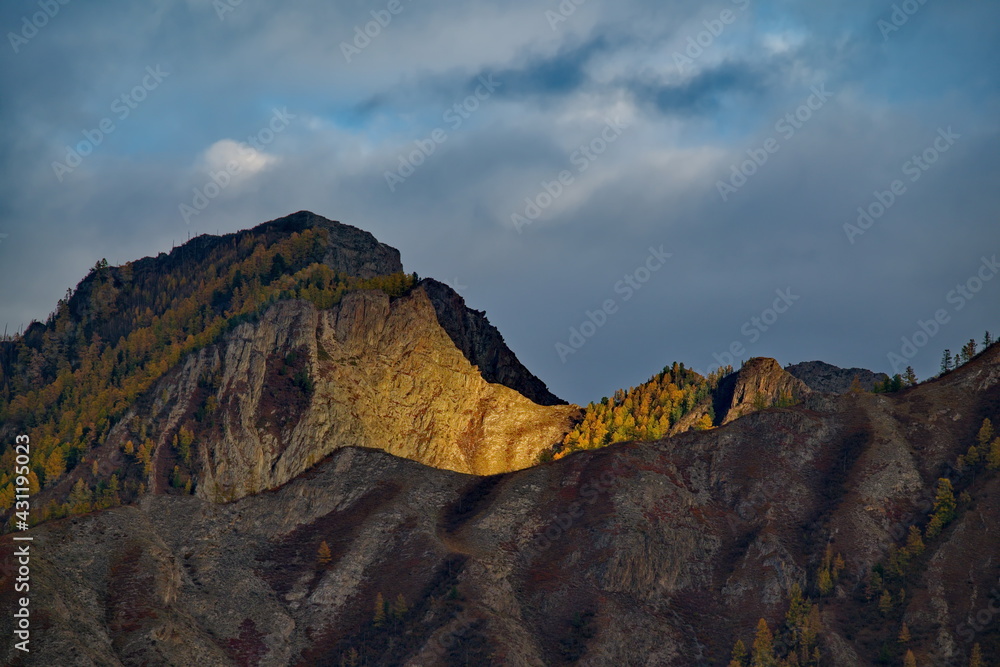 Russia. Mountain Altai. Expressive graphics of autumn sunlight on the rocks of mountain ranges.
