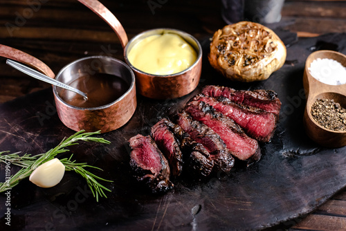 Fotografie rib eye steak on a wooden cutting board in a steak house