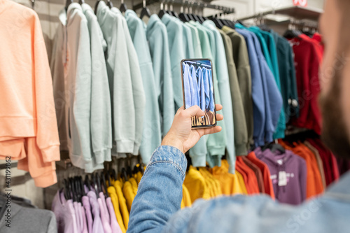 A person taking photo of new fashion collection during shopping