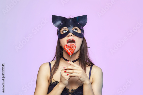 Canvas Print attractive girl in cat mask licking candy
