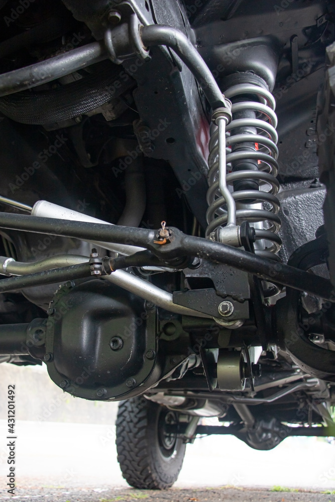 Off-road car chassis with a detailed view of the coil spring at the front wheel. - obrazy, fototapety, plakaty 