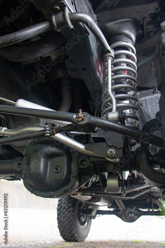 Off-road car chassis with a detailed view of the coil spring at the front wheel.