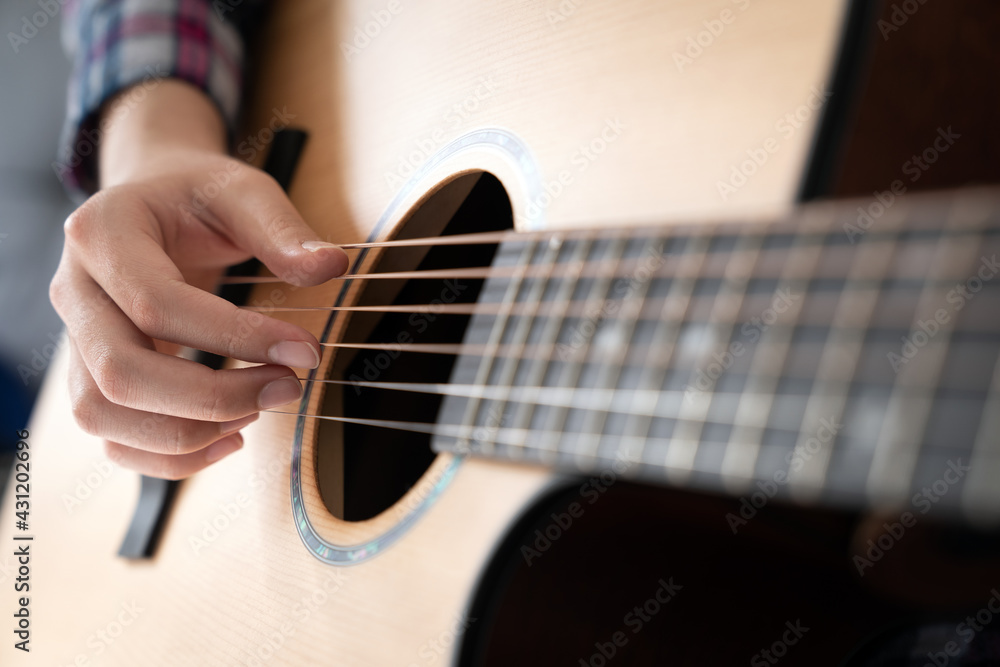 Fototapeta premium Woman's hands playing acoustic guitar, close up