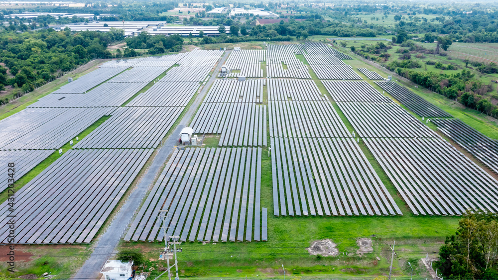 Aerial view of solar panels or solar cells on the roof in farm. Power plant with green field, renewable energy source in Thailand