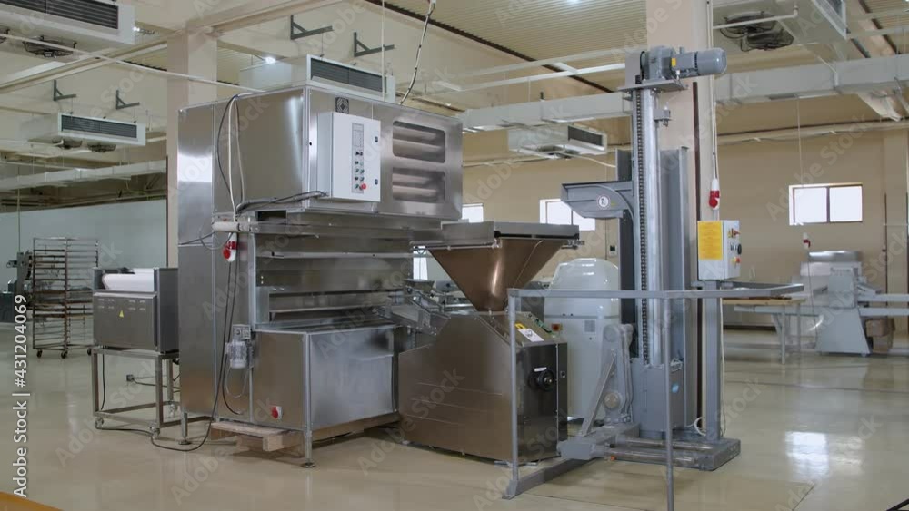 Big dough machine for mixing, cutting and rolling dough in the middle of large bakery. Slow motion Big dough machine for mixing, cutting and rolling dough in the middle of large bakery. Slow motion