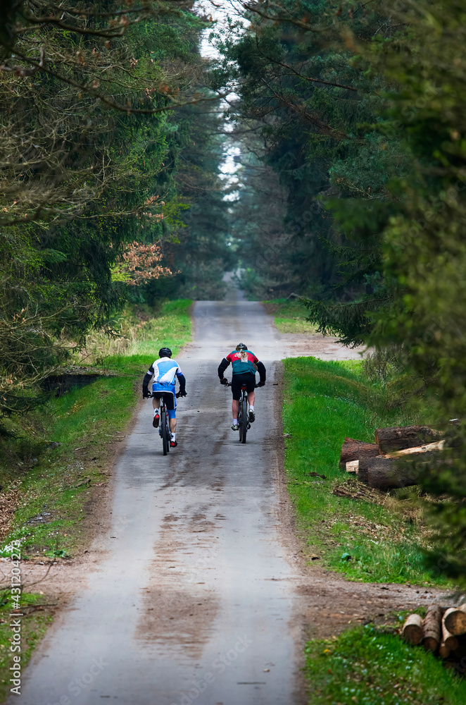 Cycling woman and man riding on bikes at sunset mountains forest landscape. Couple cycling MTB enduro flow trail track. Outdoor sport activity. Cycling woman and man riding on bikes at sunset mountains forest landscape. Couple cycling MTB enduro flow trail track. Outdoor sport activity.
