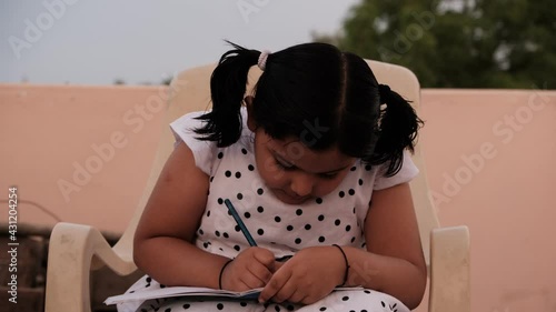 Little girl studying or writing at home