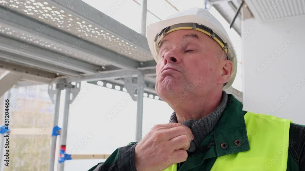 cheerful senior male builder foreman, worker in white hardhat, in work clothes funny dancing and having fun on construction site, crazy worker, concept of repair of buildings, structures