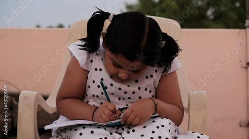 Little girl studying or writing at home