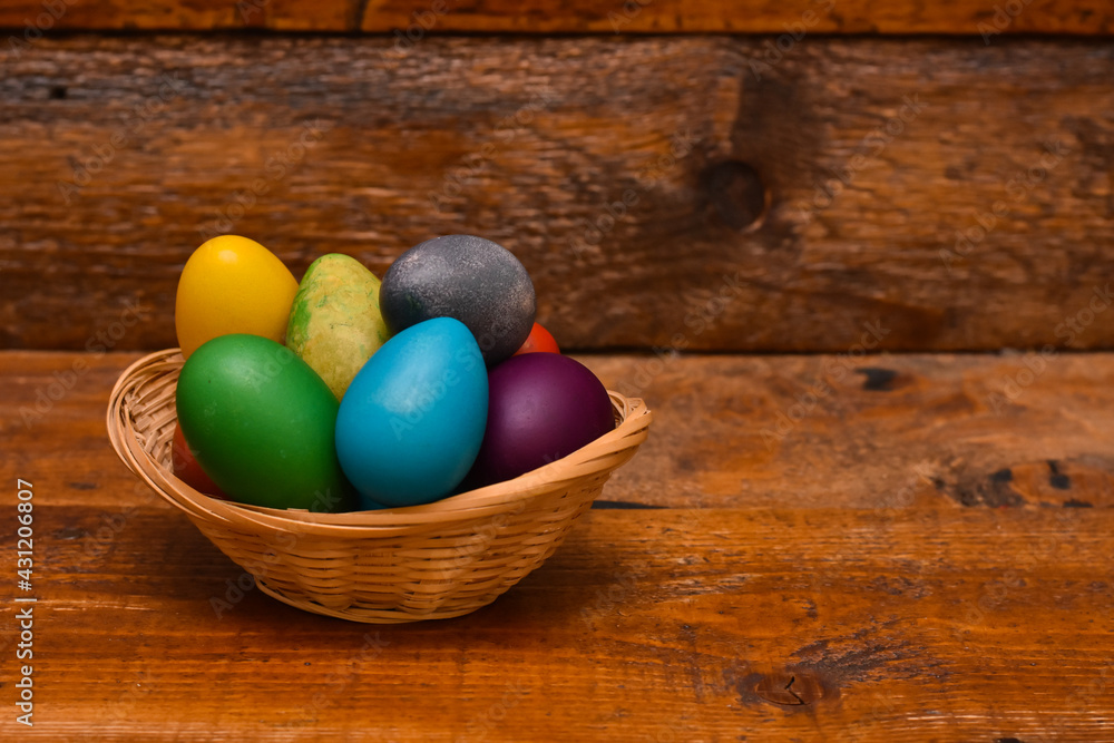 Easter eggs in basket. Colorful Easter eggs on wooden background Easter eggs in basket. Colorful Easter eggs on wooden background