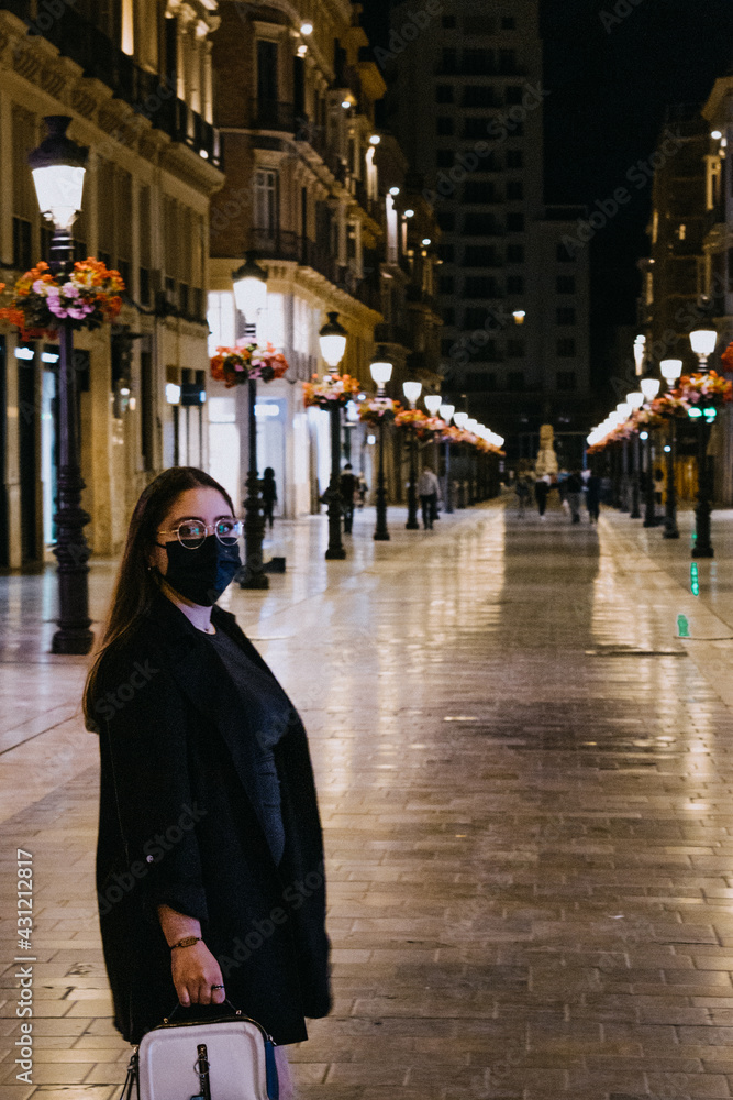 Chica guapa caminando por las calles nocturnas de Málaga