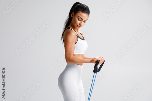 Fitness woman working out with resistance band on gray background Fototapet