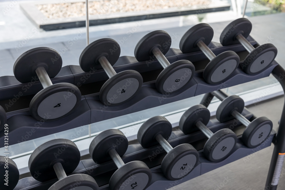 Dumbbell set. Many metal dumbbells on rack in sport fitness center. Weight Training Equipment concept. Fitness equipment dumbbells weight for workout. Rows of dumbbells in the gym Dumbbell set. Many metal dumbbells on rack in sport fitness center. Weight Training Equipment concept. Fitness equipment dumbbells weight for workout. Rows of dumbbells in the gym