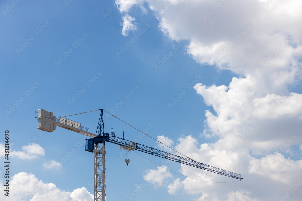 Tower Crane in the clouds and blue sky. The Crane tower in construction site of a high-rise condominium. High cranes on the construction site