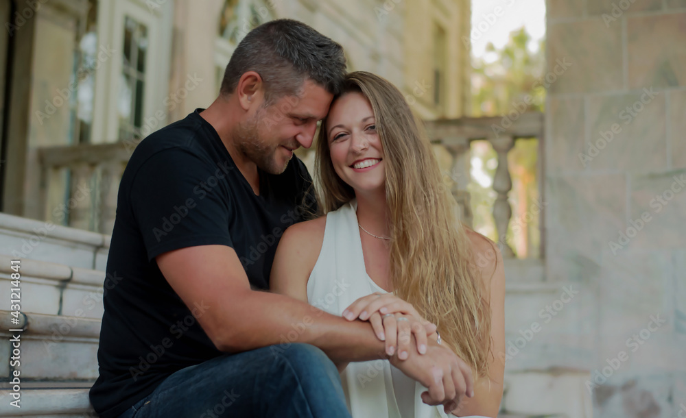 Loving Young Couple Sitting on Steps with Architectural Background Smiling Loving Young Couple Sitting on Steps with Architectural Background Smiling